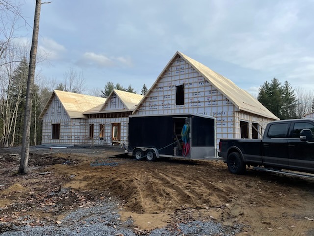 Grande maison unifamiliale en construction avec remorque d'équipement d'isolation sur le chantier