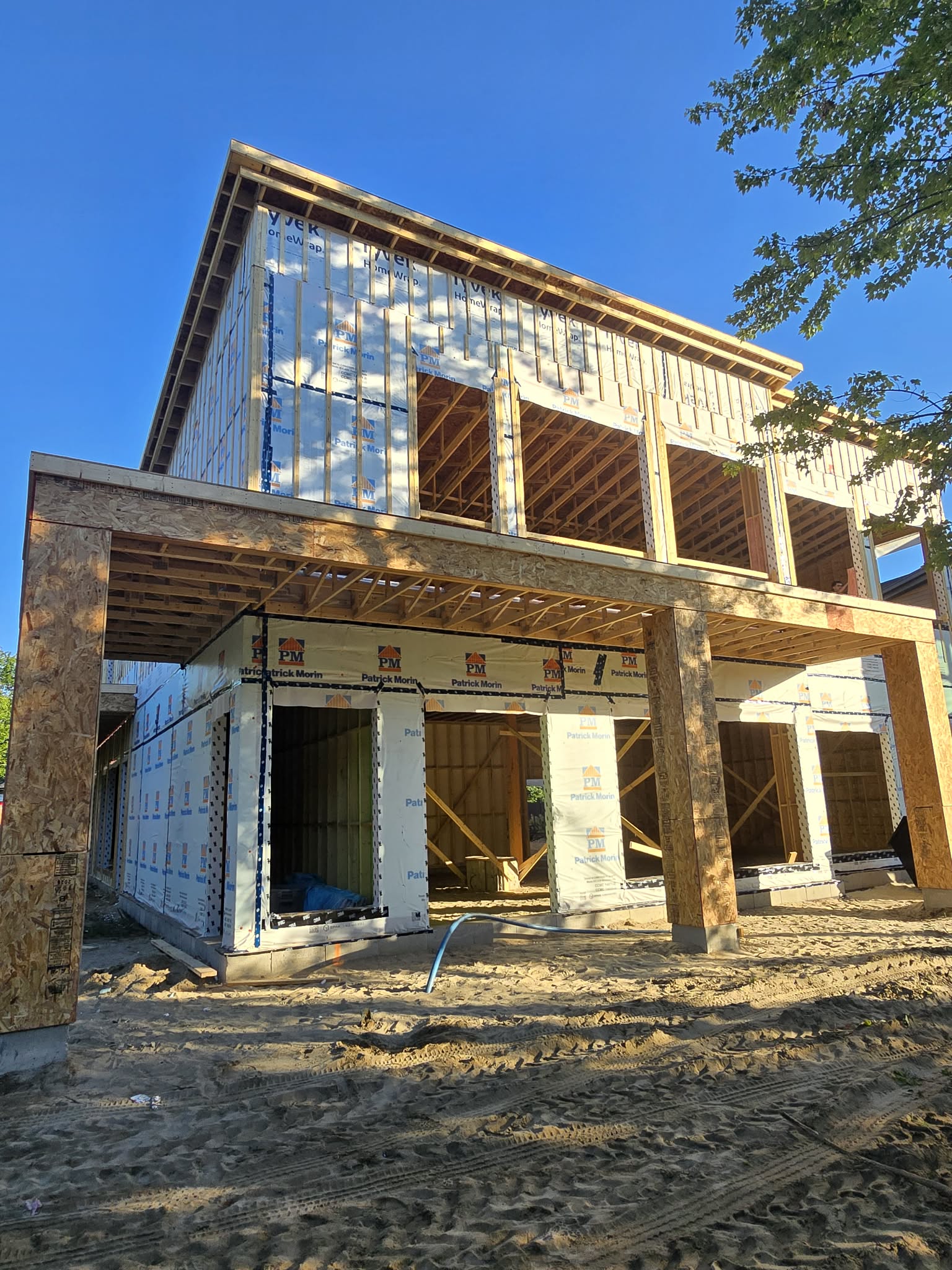 Maison moderne à deux étages avec pare-air Tyvek et structure de porche couvert